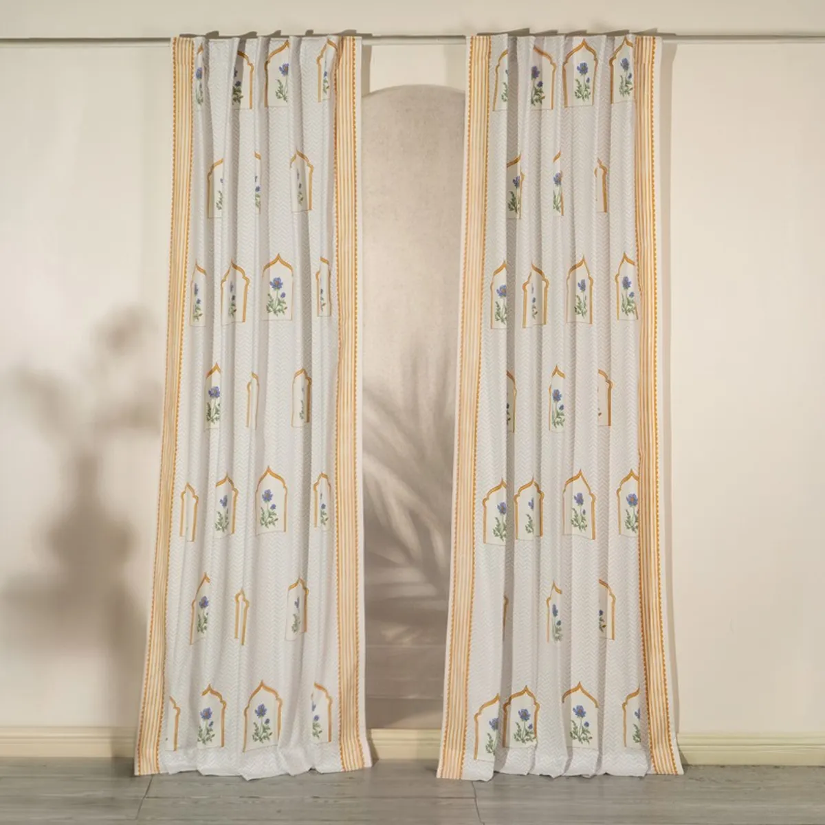 Pair of yellow and white patterned curtains hanging on a window