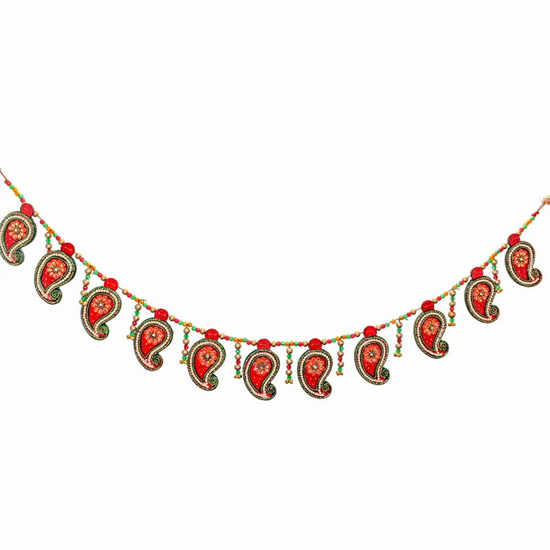 Wide view of red and green toran with repeated hanging motifs
