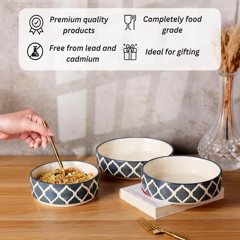 Blue and white patterned bowls arranged on a table beside dining accessories.