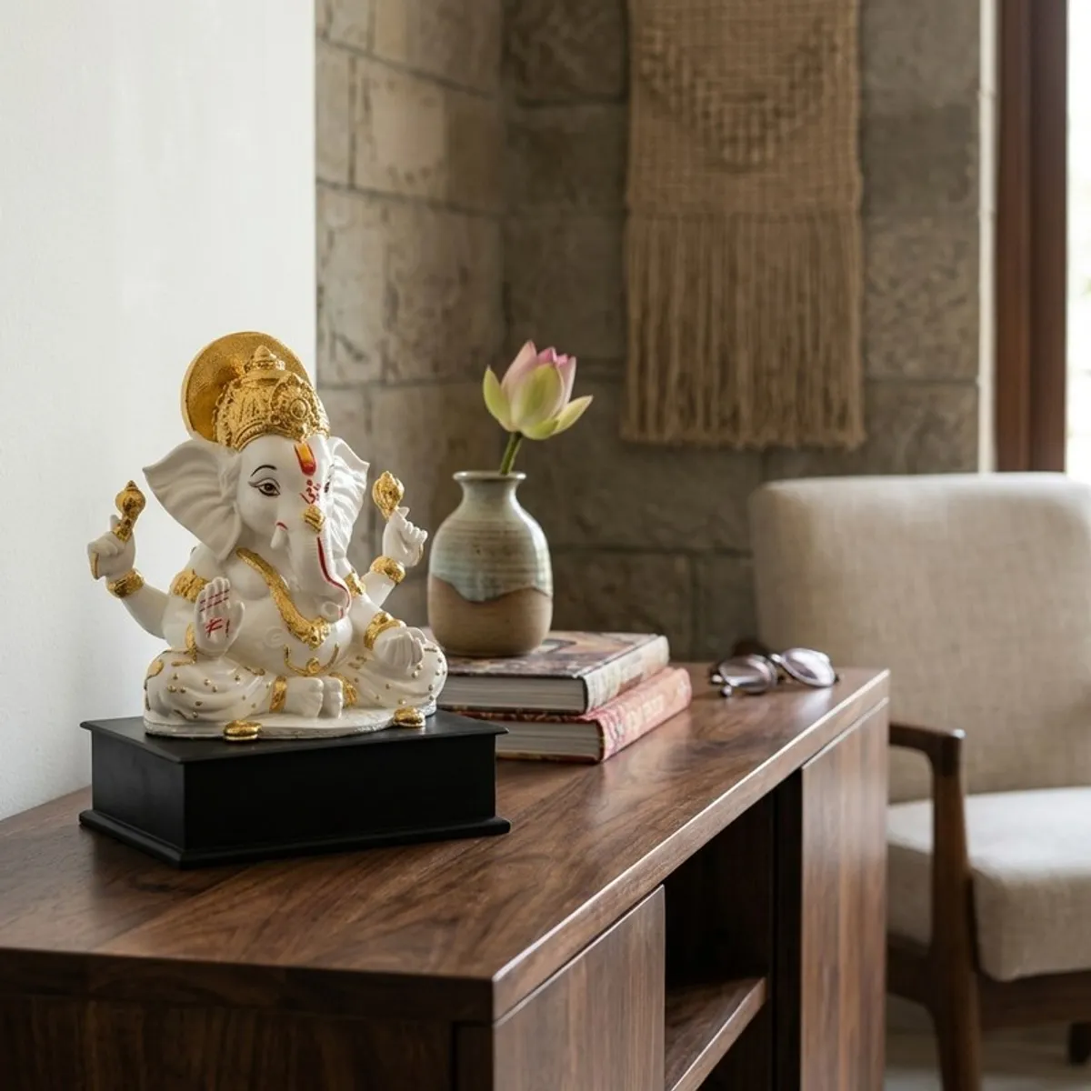 White and gold Ganesha idol displayed on a wooden sideboard in a modern room