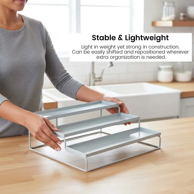 Person holding a white metal tiered organiser on a kitchen counter