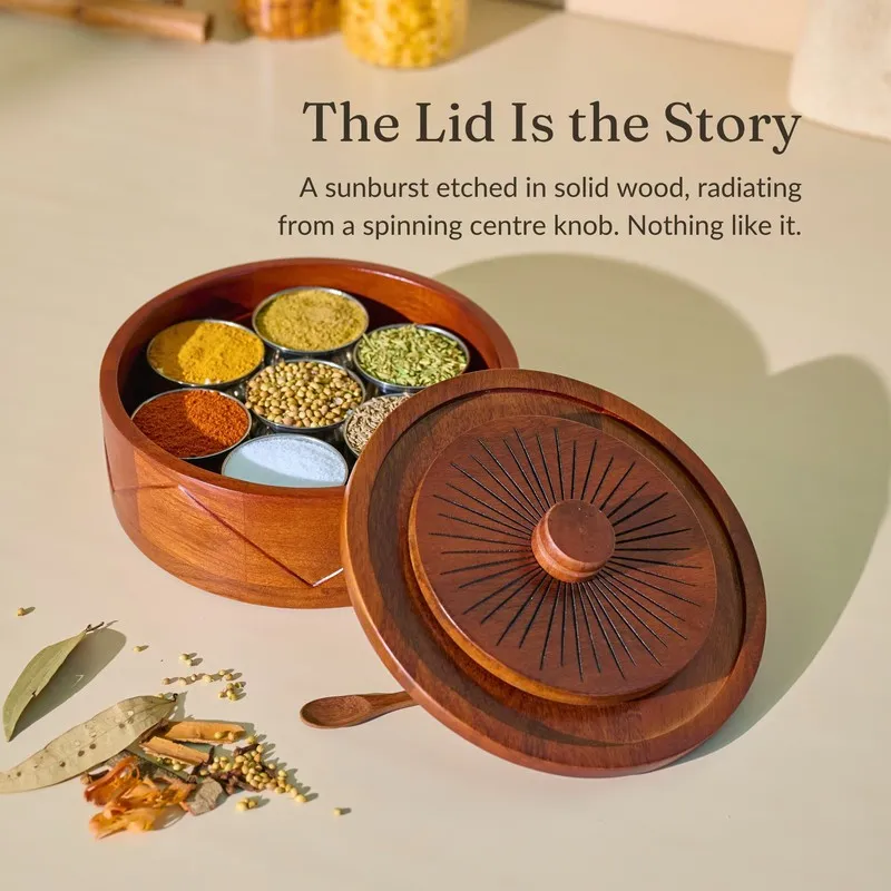 Open brown masala box with sunburst lid placed beside seven spice compartments