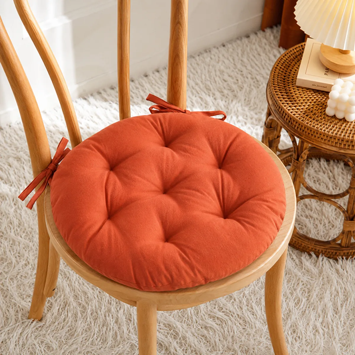 Terracotta brown round chair pad tied onto a wooden dining chair