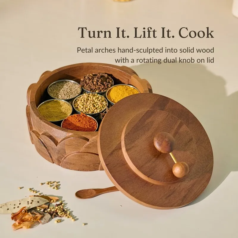 Open wooden masala box with seven visible steel spice compartments and a detached round lid.