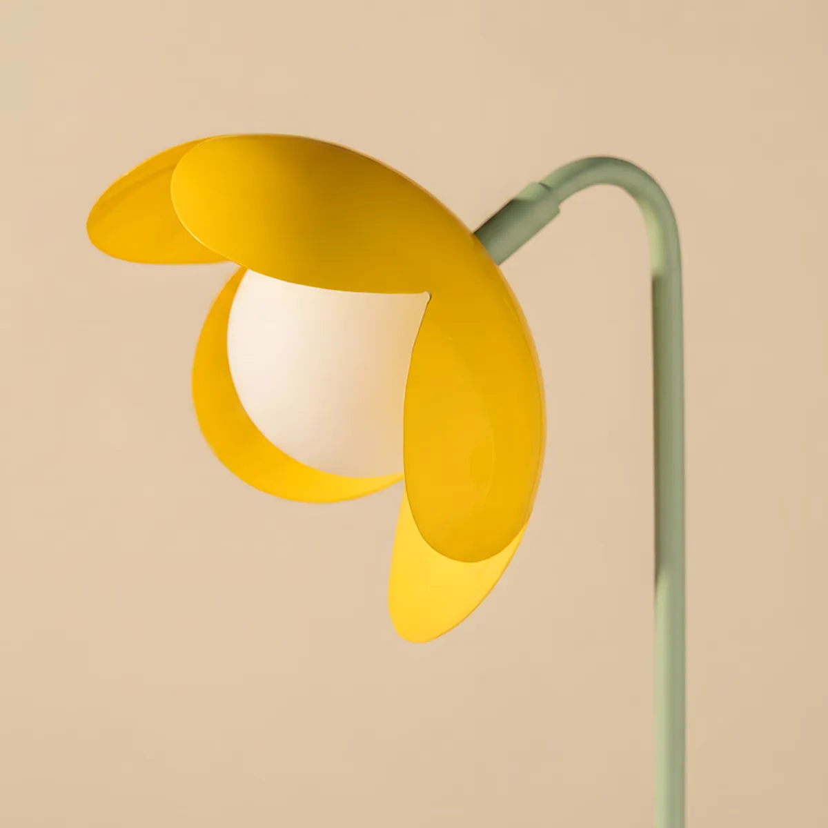 Side view showing the yellow flower shade and curved green lamp stem