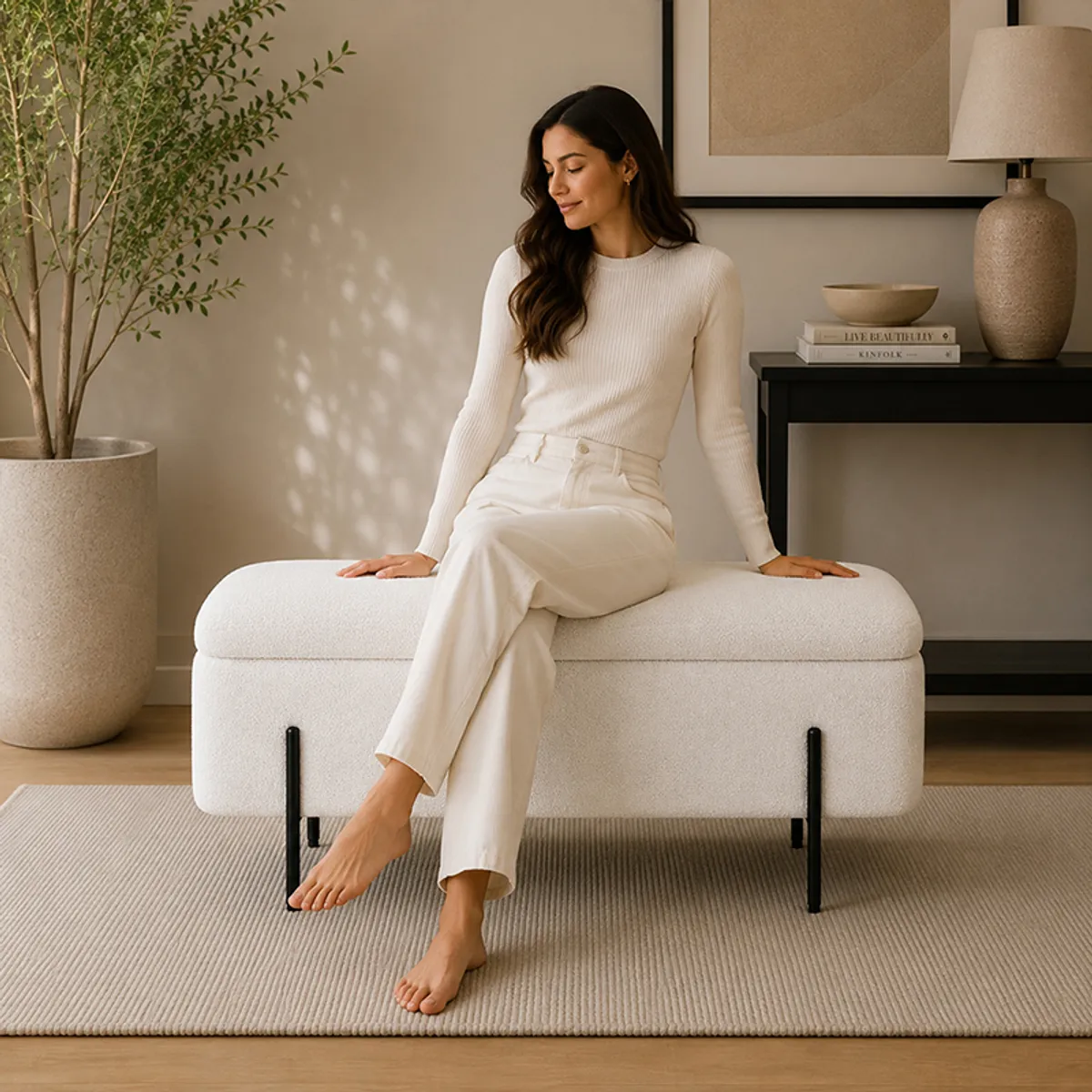 White fabric storage bench with black metal legs styled in a warm modern room