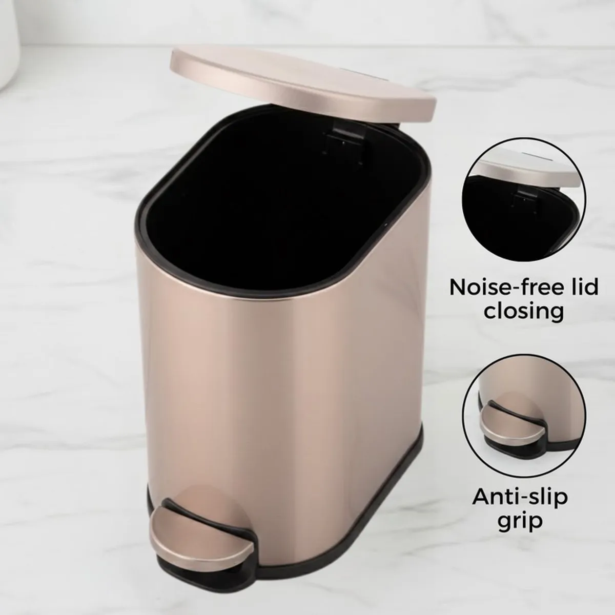 Open gold metal dustbin with black interior and pedal base