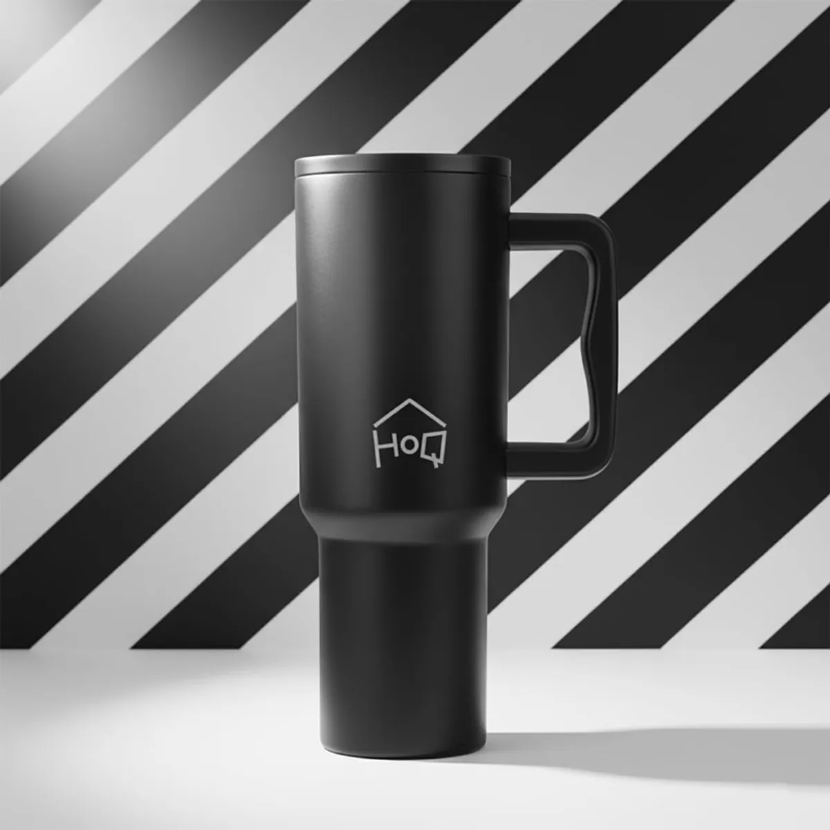 Black handled tumbler displayed against a bold black and white backdrop