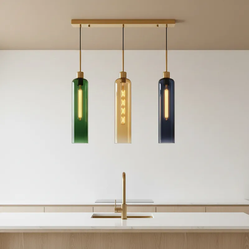 Linear pendant lamp with coloured glass shades suspended above a kitchen island