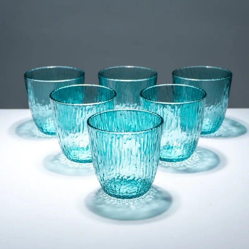 Five blue textured drinking glasses with one placed in front
