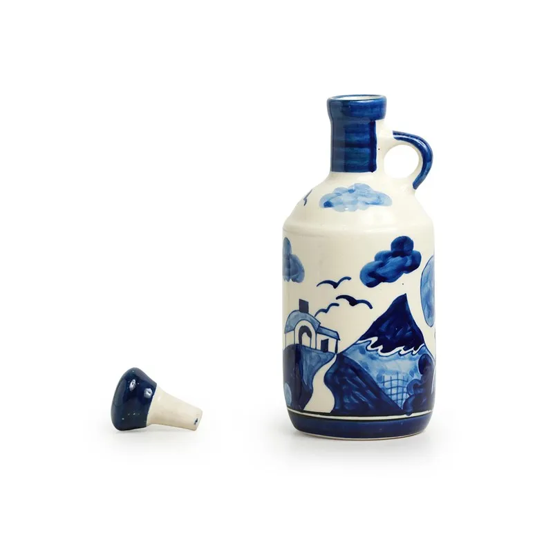 Blue and white ceramic oil dispenser showing its illustrated landscape design and stopper.