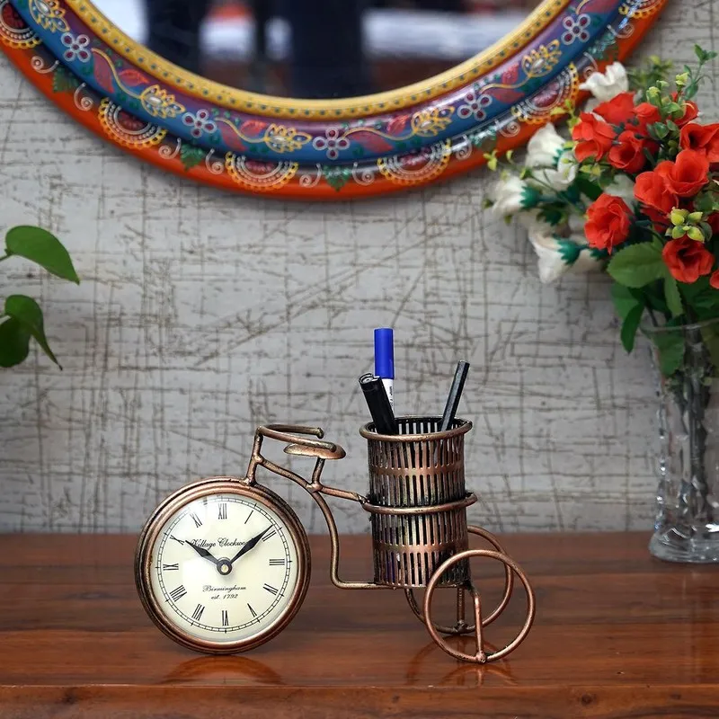 Decorative bicycle pen stand holding pens on a tabletop