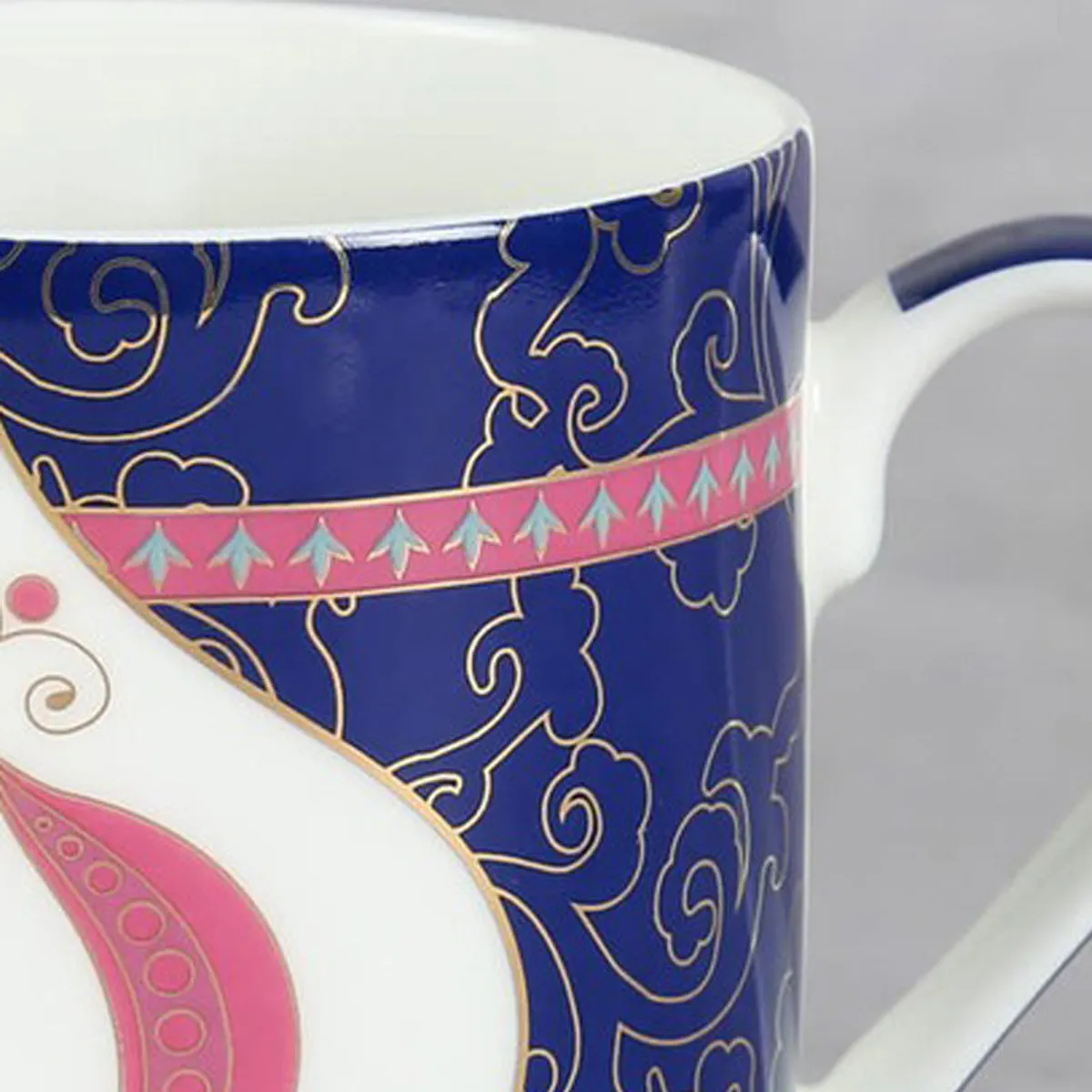 Close-up showing the ornate blue pattern and curved white mug handle