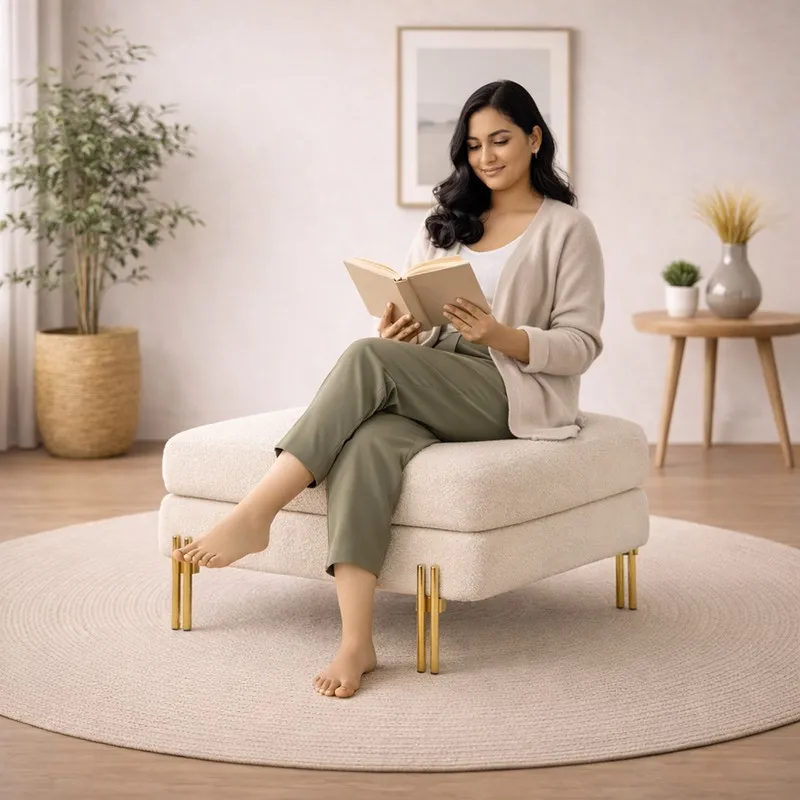 Person seated on a white bouclé ottoman with gold legs