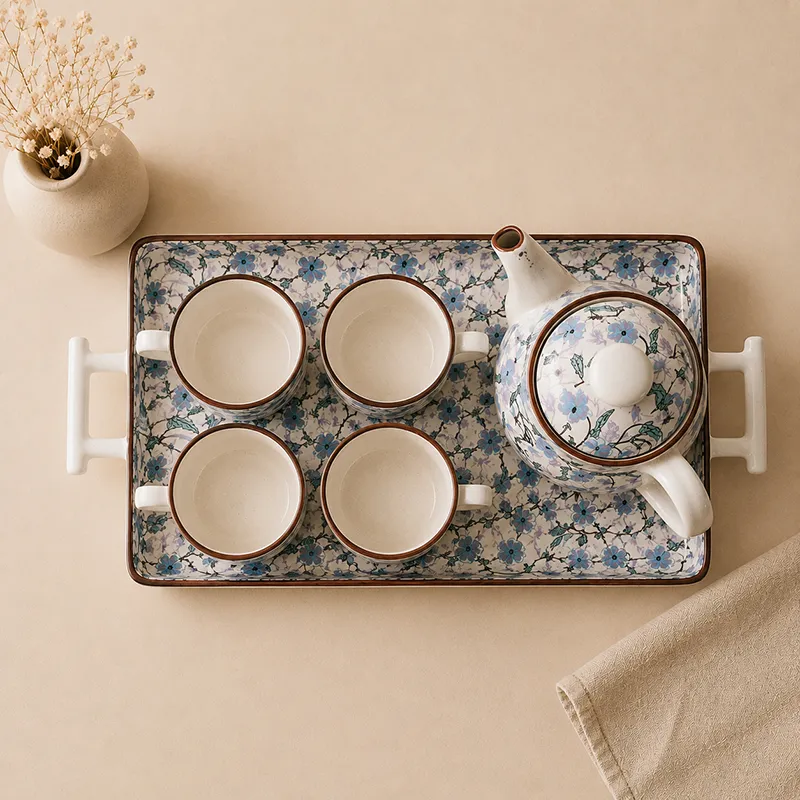 Overhead view showing four cups, teapot and patterned serving tray