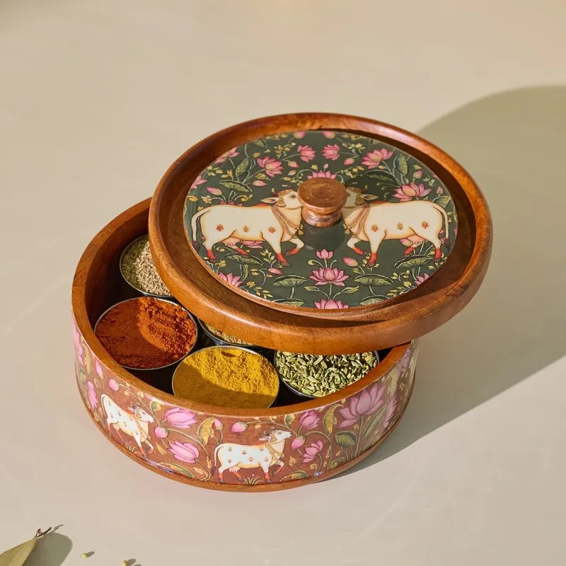Closed round wooden masala box with floral Pichwai lid and visible spice compartments