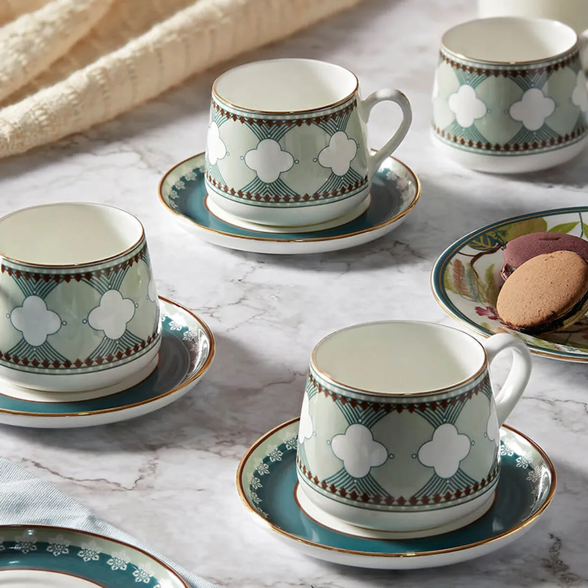 Close view of a teal and white cup with a matching saucer and decorative pattern