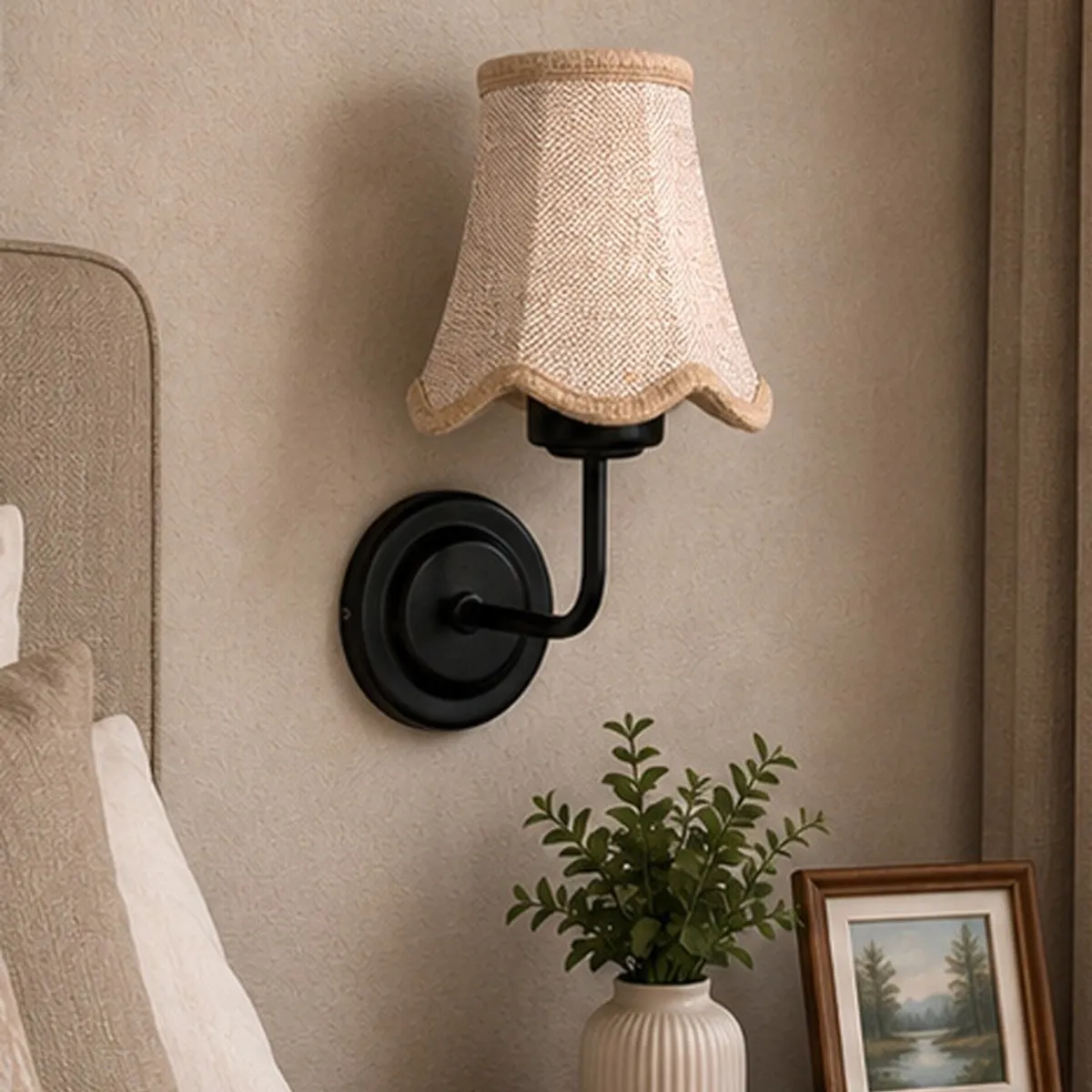 Beige-shade black wall lamp styled beside a bed and potted plant