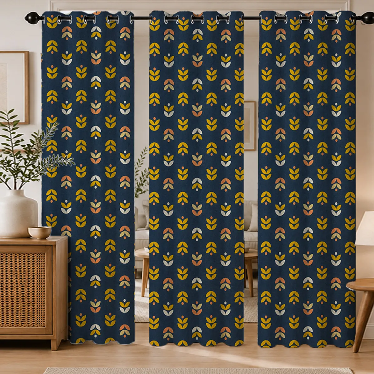 Set of three blue floral eyelet curtains hanging in a living room
