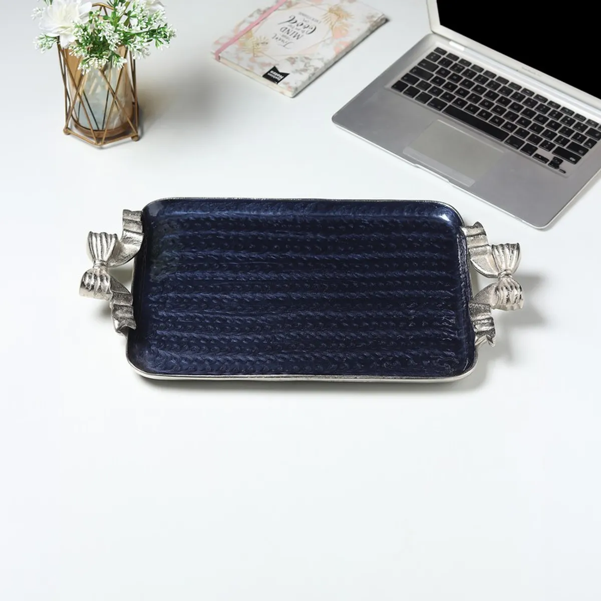 Top view of a blue rectangular tray with a reflective surface and silver bow handles