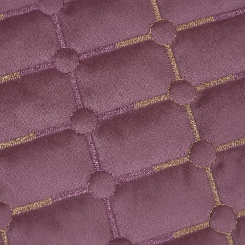 Close-up of geometric embroidered detailing on the wine-purple velvet cover