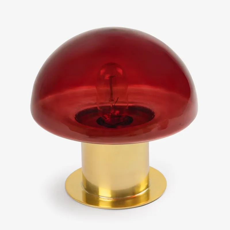 Front view of a red semi-sphere glass shade on a gold lamp base