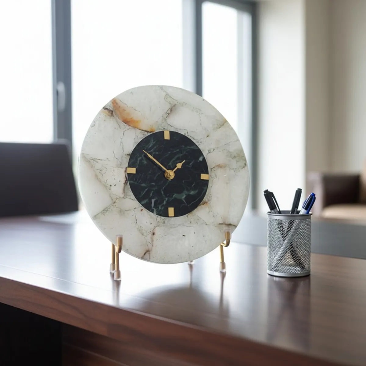 Round agate table clock with gold stand placed on an office desk