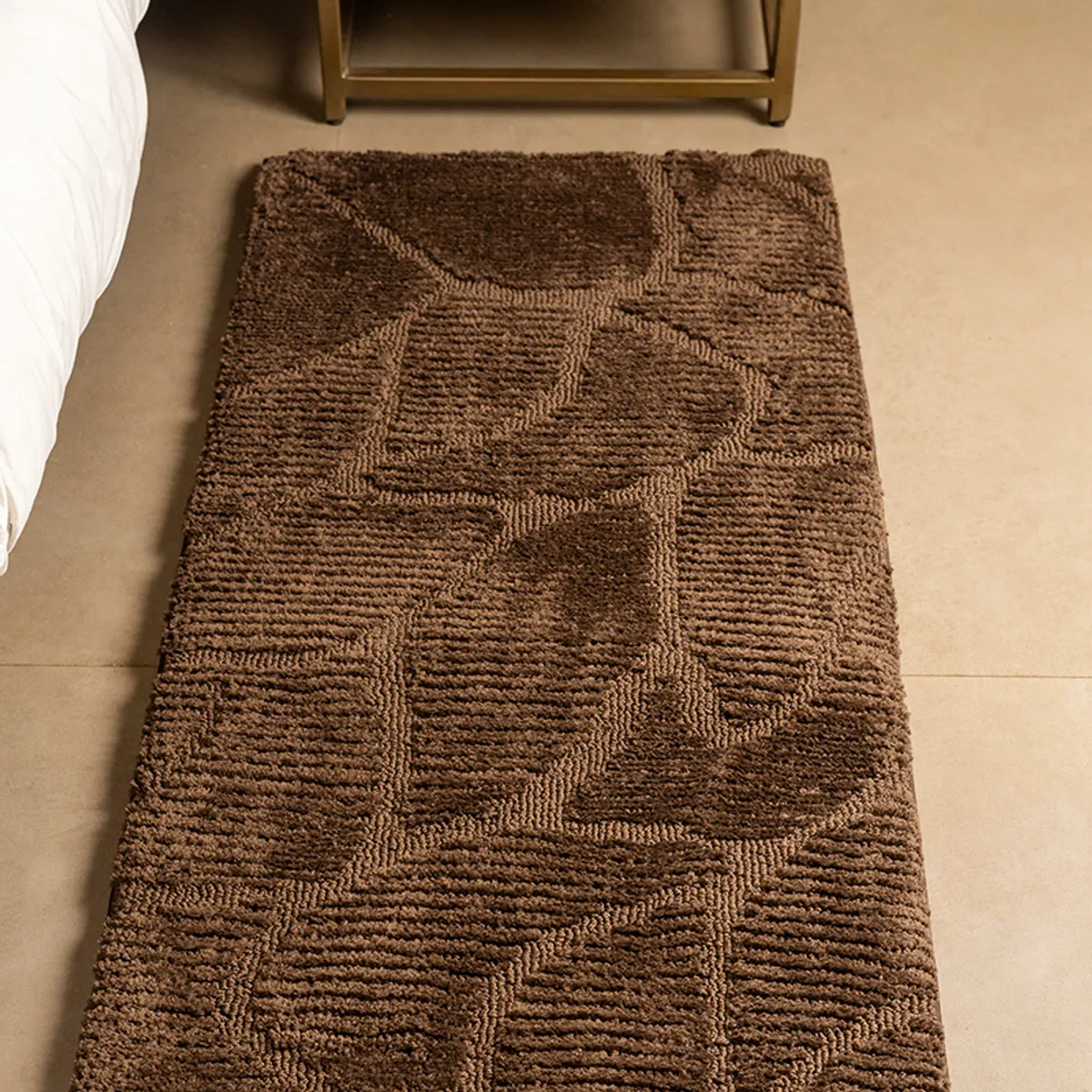 Close view of the brown abstract-patterned runner beside a bed