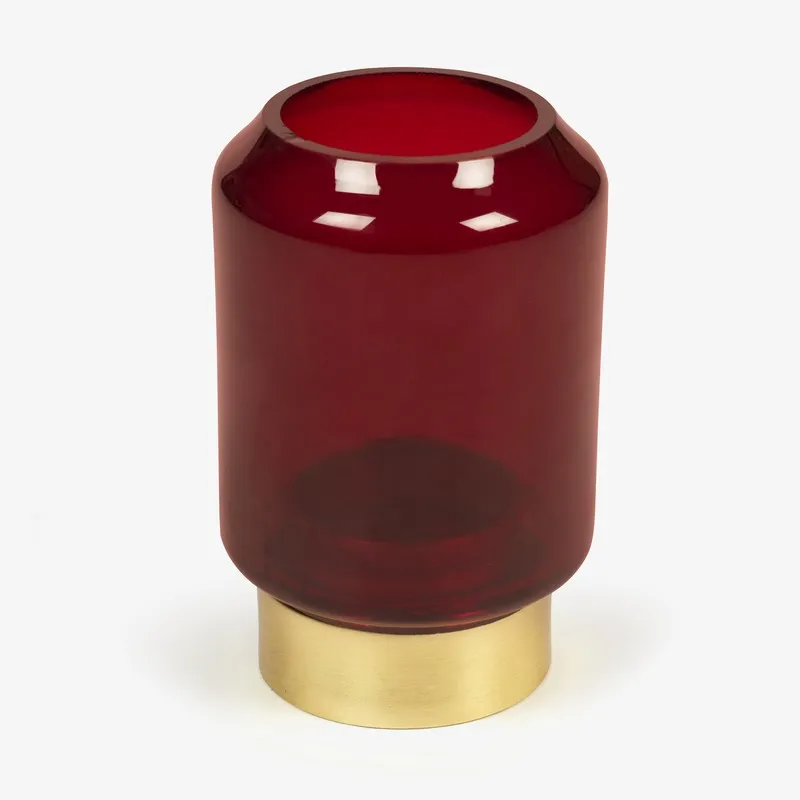 Angled view of ruby red glass candle holder with gold base