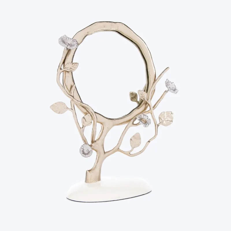 Front view of a round floral mirror with branching leaves on a white base.