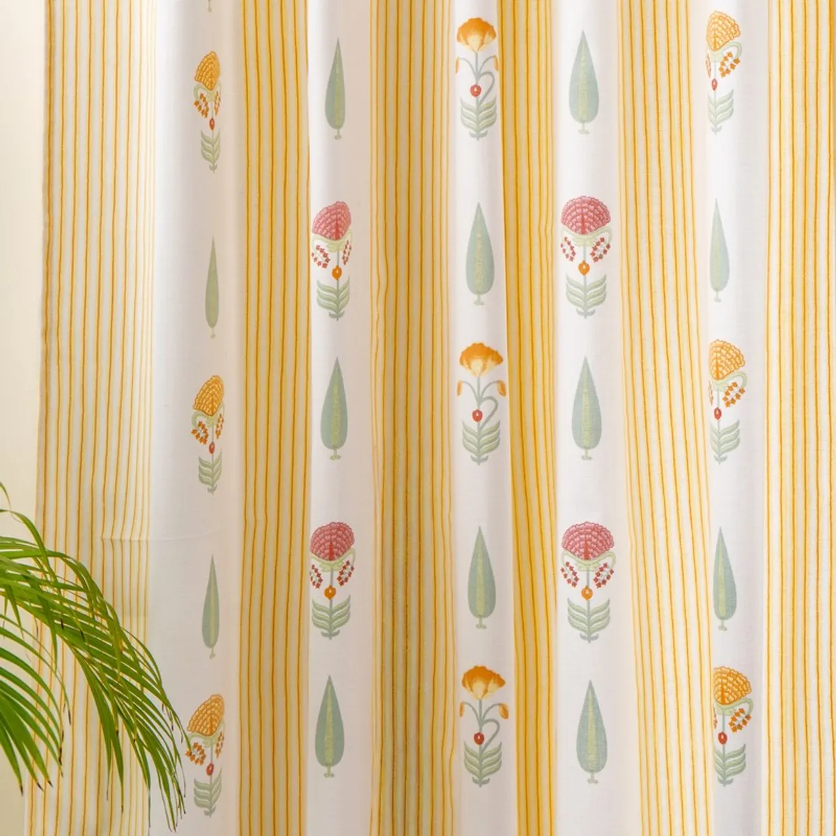 Detailed view of yellow striped curtains with repeated floral and leafy pattern