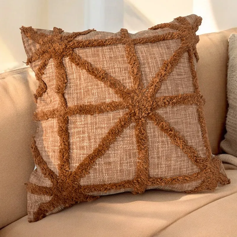Brown square cushion cover with raised geometric tufted lines on a sofa