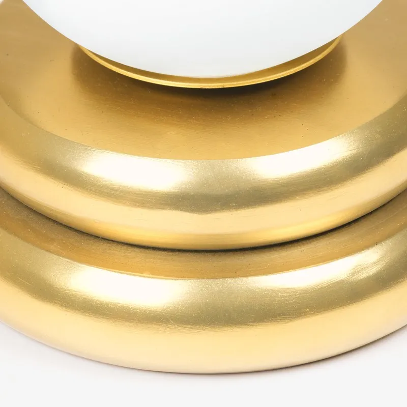 Close-up of the gold-toned rounded base of the table lamp