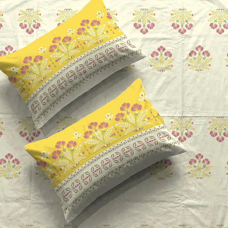 Close-up of yellow floral pillow covers and off-white bedsheet with small floral motifs
