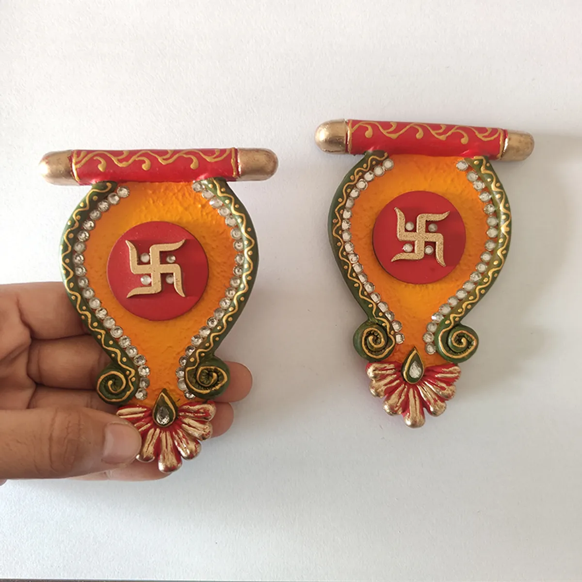 Two handcrafted Sacred Swastik accents shown against a wall