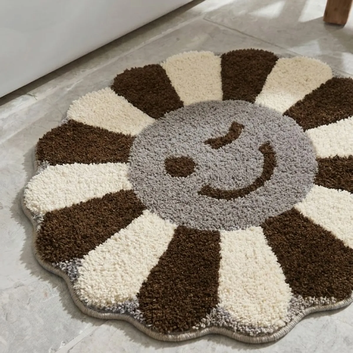 Close-up of a plush flower-shaped bath mat with brown, cream and grey sections