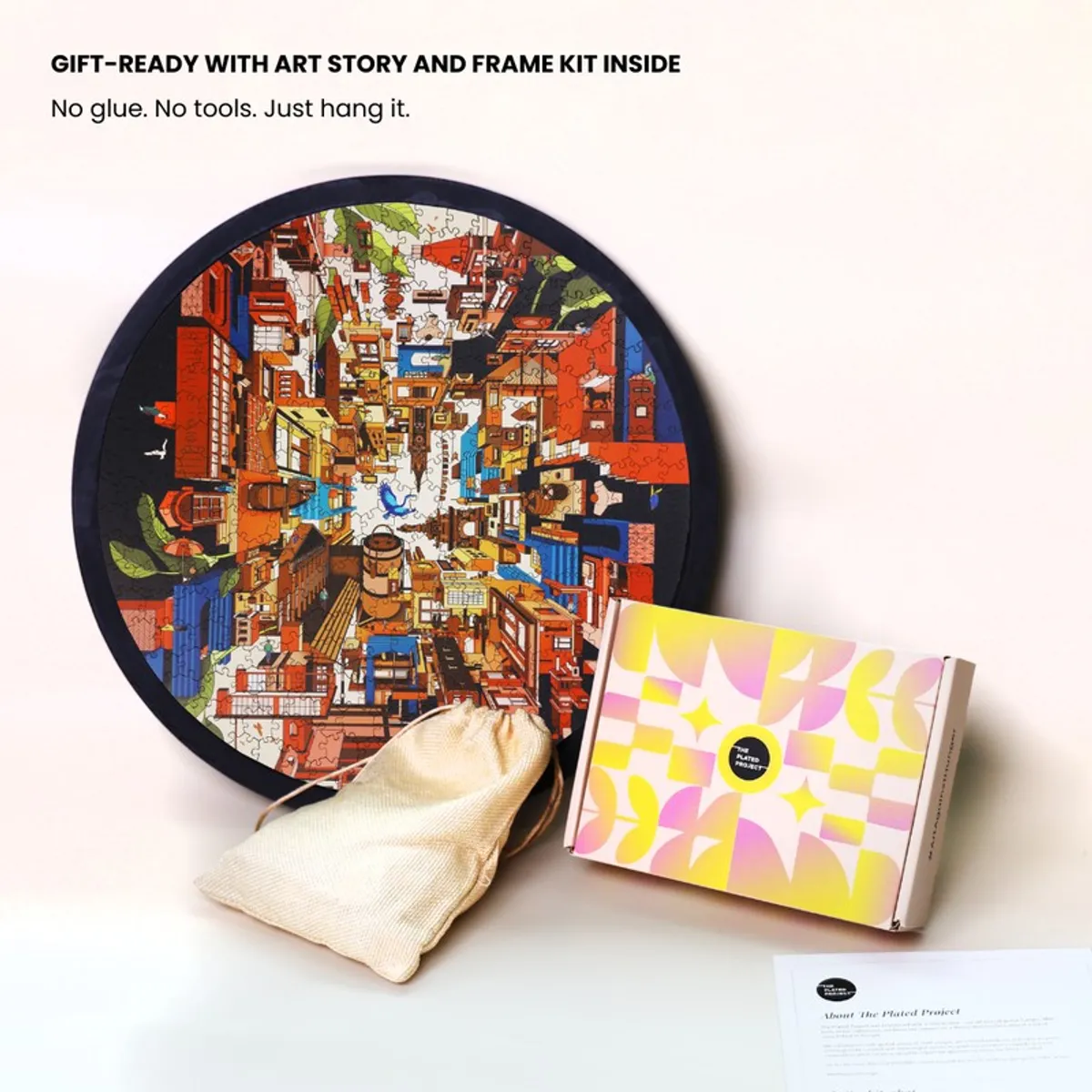 Round framed cityscape puzzle art with a pouch, box and printed card beside it