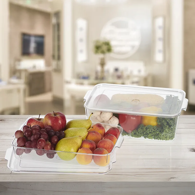 Two transparent organisers displayed with fruit and vegetables in a kitchen setting.