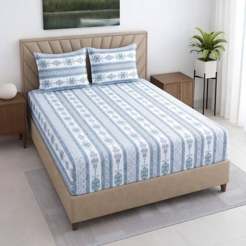 Blue and white fitted bedsheet with striped geometric print on a bed