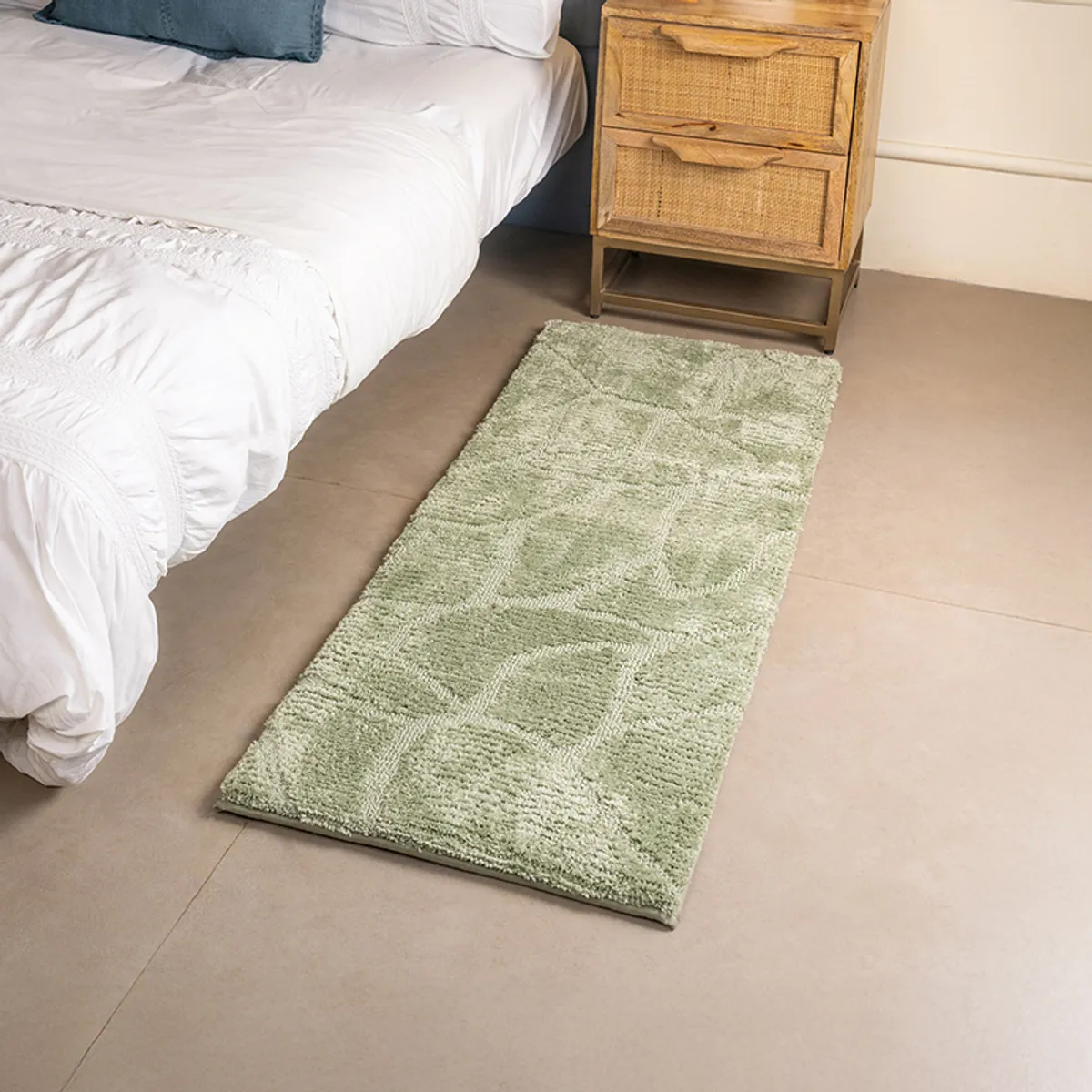 Green anti-skid runner rug styled beside a bed in a contemporary bedroom
