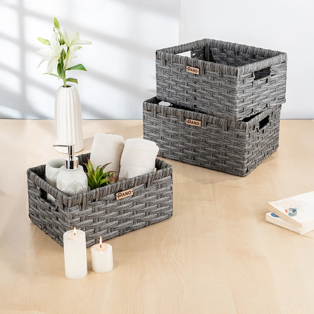 Three grey rectangular storage baskets styled on a tabletop