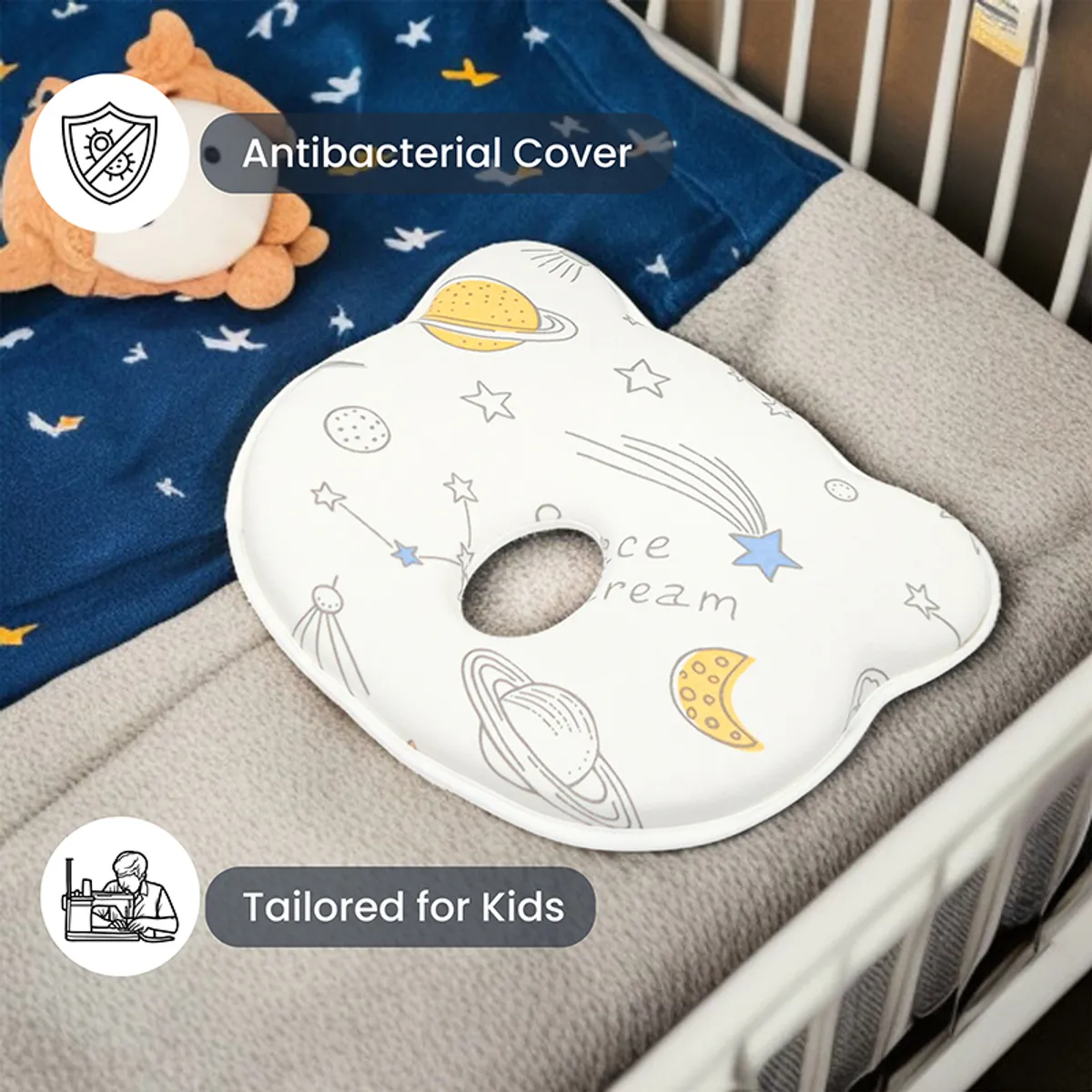 Space-print baby pillow placed inside a crib