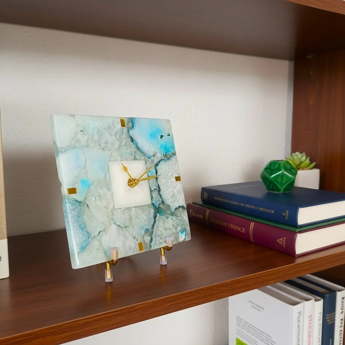 Square agate clock on a shelf beside stacked books