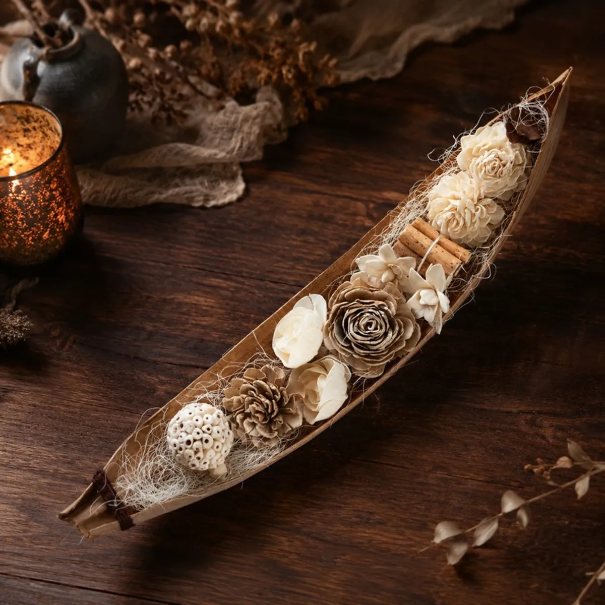 Brown and off-white floral arrangement displayed on a dark wooden table