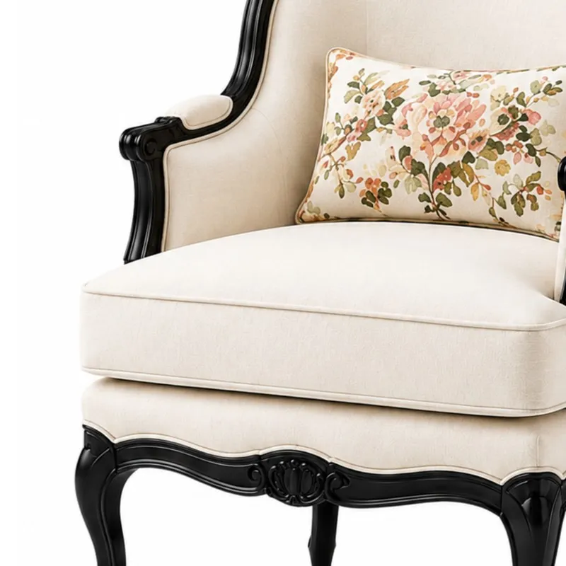 Close-up of off-white seat cushion, black carved frame and floral cushion