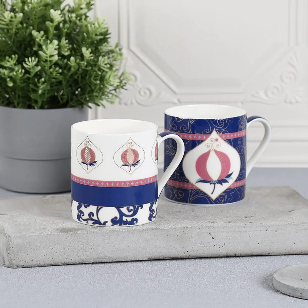 Pair of blue and white pomegranate coffee mugs with curved handles