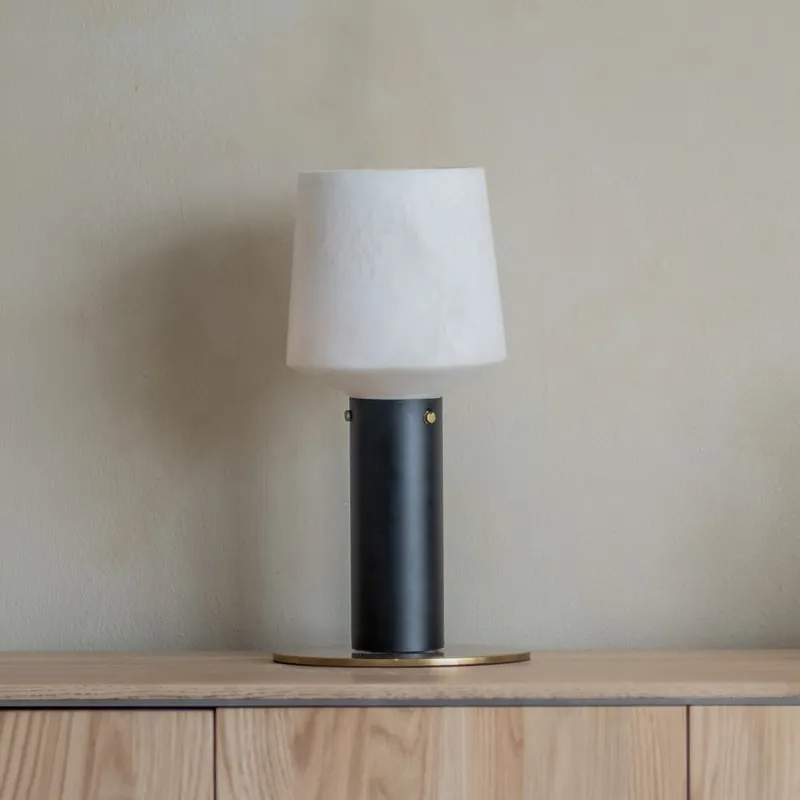 Front view of black and off-white table lamp on a cabinet