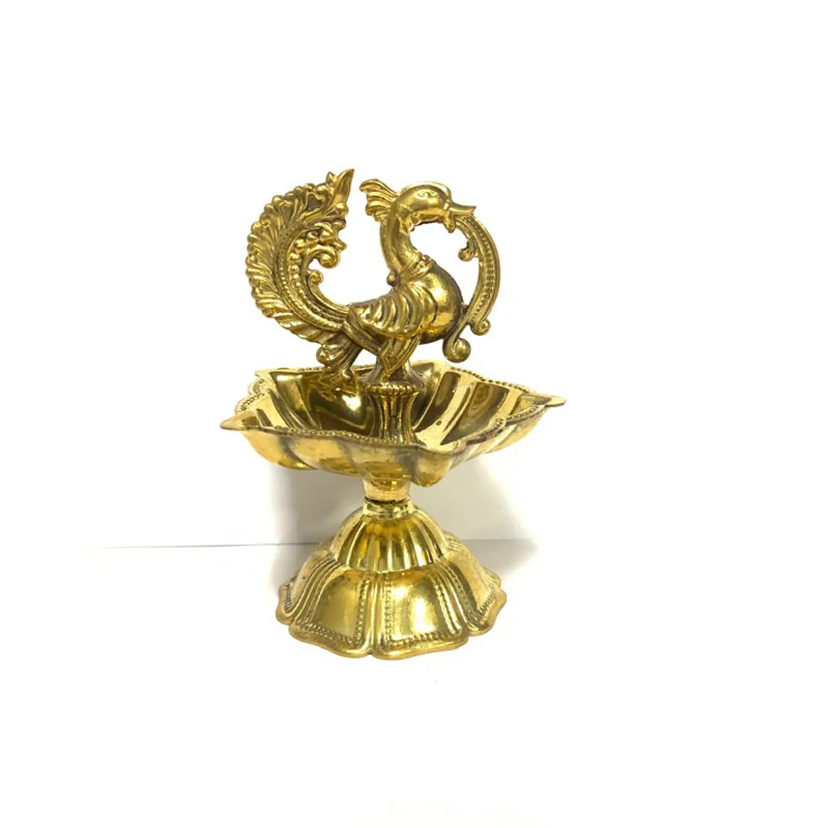 Gold peacock brass diya shown against a plain light background