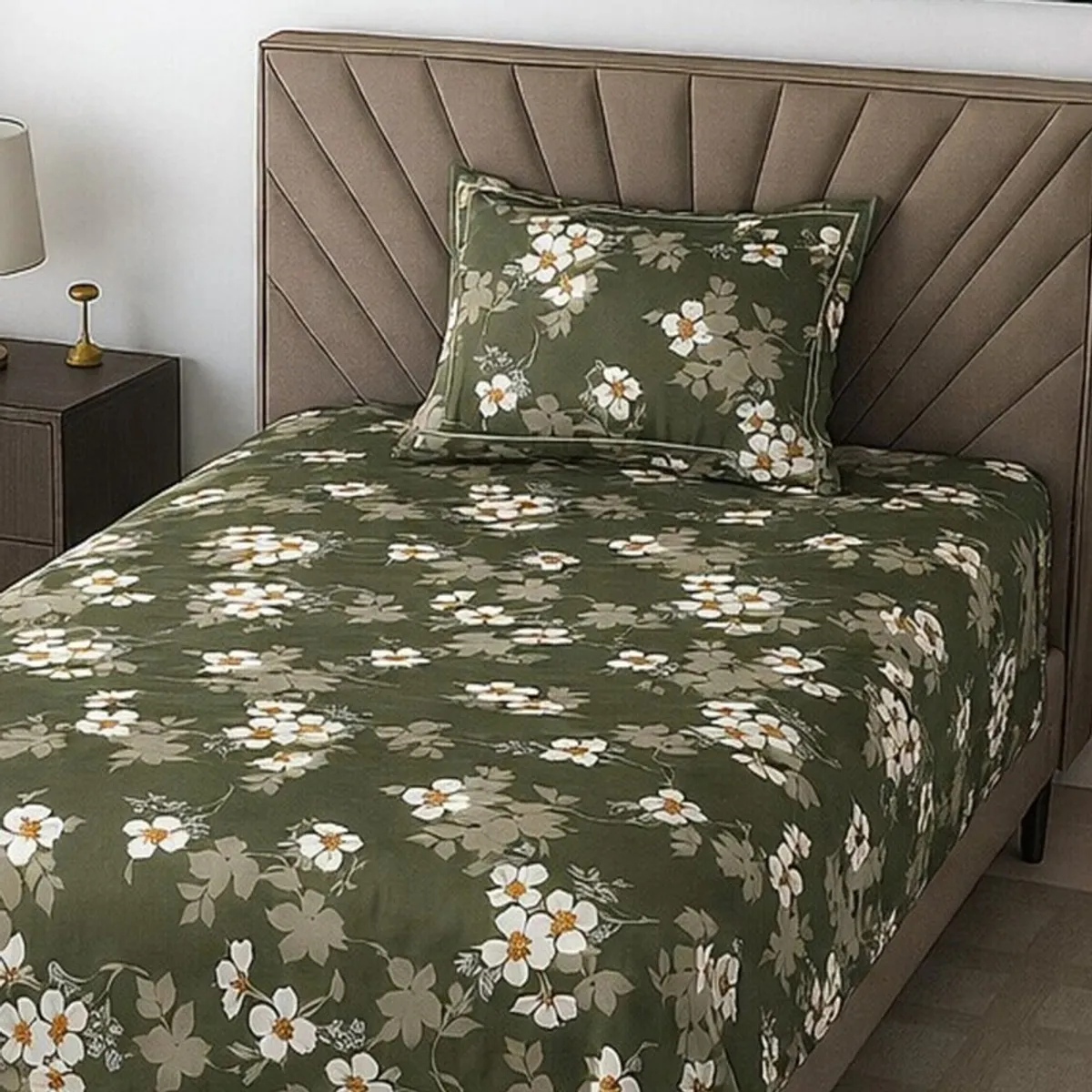 Close view of green floral bedsheet spread across a bed