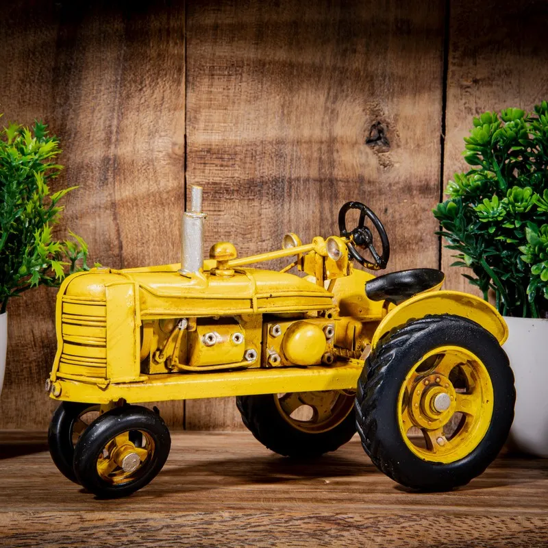 Yellow vintage tractor decor piece styled on a wooden surface